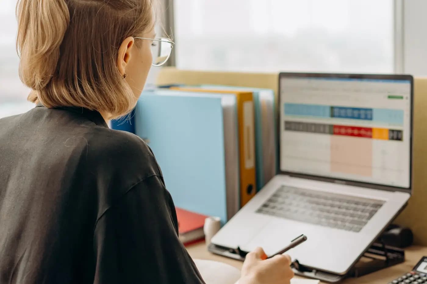 Employee analysing data in a spreadsheet on a laptop
