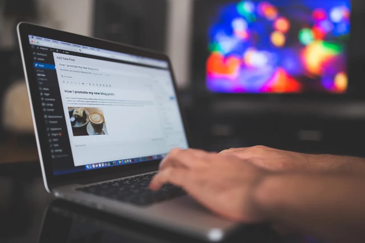 Hände tippen auf einem Laptop mit geöffnetem WordPress-Editor