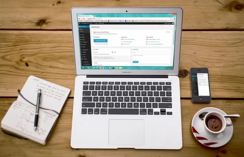 Laptop mit geöffnetem WordPress-Dashboard auf einem Holztisch