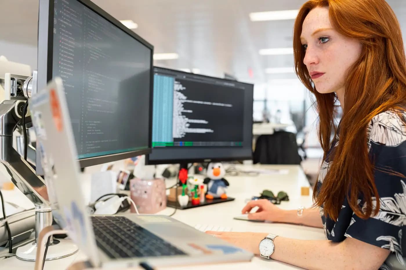 Developer working on code across two monitors
