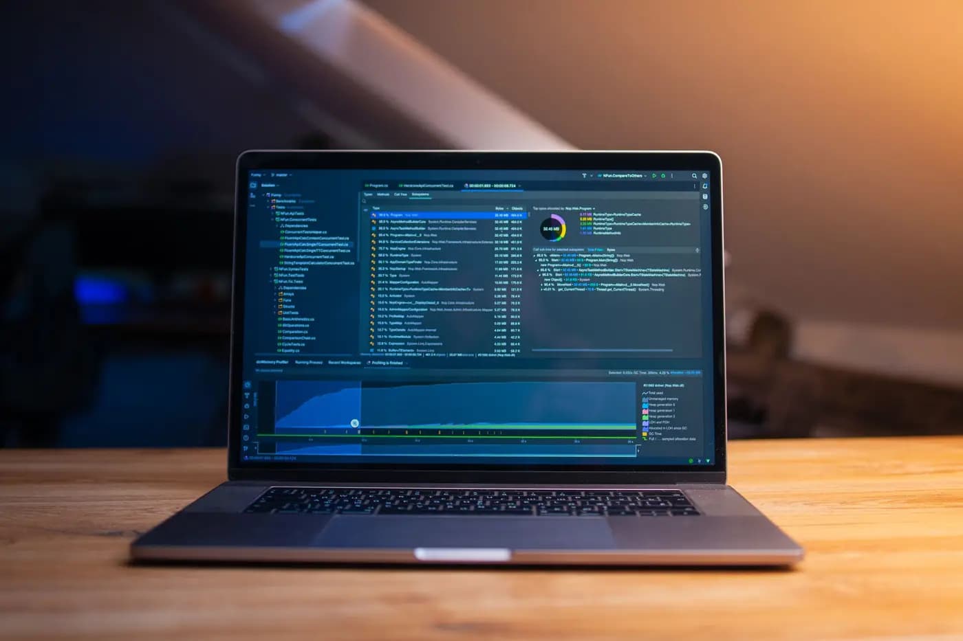 Laptop with a development environment and performance analysis on a wooden table